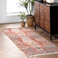 a large rug is on the floor next to a plant