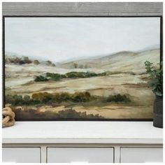 a painting is shown on a shelf with a teddy bear next to it and a plant in the foreground