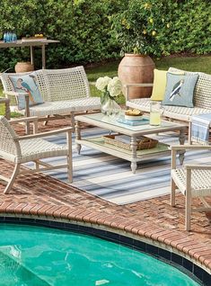 an outdoor patio with chairs and tables next to a swimming pool