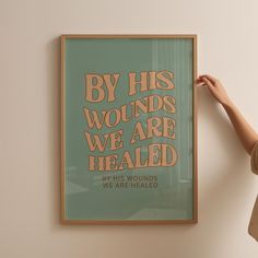 a woman is holding up a poster with words on it that say by his wounds we are healed