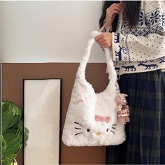 a woman holding a white hello kitty bag