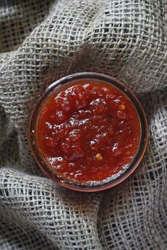 a small bowl filled with sauce on top of a cloth