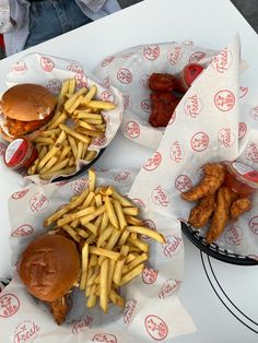 three baskets filled with different types of food sitting on top of a white table covered in red and white paper