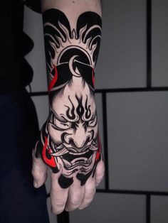 a person with a tattoo on their arm and hand holding a red object in the other hand