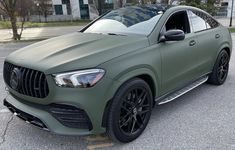 a green mercedes suv parked in a parking lot