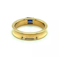 An elegant and authentic stack ring from Tiffany & Co. It is crafted from 18k yellow gold with a polished finish and features a 4.5mm wide concave design around the entire band with two channel set baguette sapphires.  It is signed by the designer with the gold content.    Brand:   Tiffany & Co.  Hallmark:  1997 Tiffany & Co. 750  Sapphire: 0.30ct  Material:  18k yellow gold  Measurement:  0.19" wide x 0.11" high  Ring Size:  6  Weight: 5.8 grams Luxury Yellow Gold Emerald Ring With Polished Finish, Luxury Yellow Gold Emerald Ring With Round Band, Luxury Gold Emerald Ring With Round Band, Luxury Yellow Gold Stackable Emerald Ring, Luxury Stackable Yellow Gold Emerald Ring, Classic Formal Stackable Rings With Baguette Cut, Modern Gold Emerald Baguette Cut Ring, Luxury Yellow Gold Sapphire Ring For Anniversary, Classic Formal Stackable Baguette Cut Rings