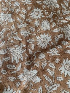 the fabric is brown and white with floral designs on it's side, as well as