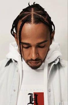 a man with dreadlocks wearing a hoodie and looking down at his cell phone