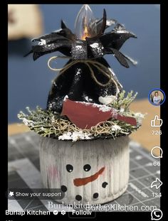 a snowman decoration on top of a potted plant