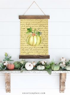 an arrangement of pumpkins and gourds on a mantle