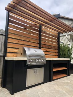 an outdoor kitchen with grill and bbq