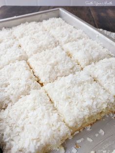 coconut bars are cut into squares on a baking sheet