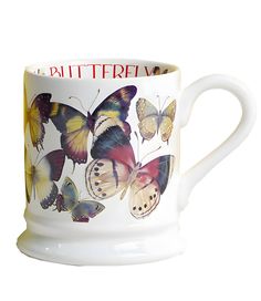 a coffee cup with butterflies painted on the side and words written in large, bold letters