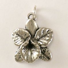 DESCRIPTION This beautiful Cattleya Orchid Charm features a detailed depiction of the iconic flower and will add that special something to any outfit! Available in sterling silver or gold vermeil, its realistic design will make heads turn as you flaunt this unique accessory. The perfect addition to your jewelry collection. Original design by Pat Frey 3/4 inch length by 5/8 inch Type: Three Dimensional Item Number: 1543 Classic Silver Jewelry With Flower Charm, Silver Botanical Jewelry With Flower Charm, Cattleya Orchid, Silver Chains, Silver Sterling, Gold Filled Chain, Accessories Unique, Item Number, Sterling Silver Chains