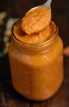 a spoon full of peanut butter on top of a jar