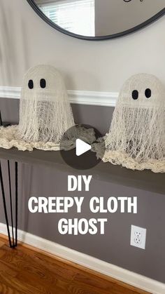 two creepy cloth ghost heads sitting on top of a shelf next to a mirror with the words diy creepy cloth ghost