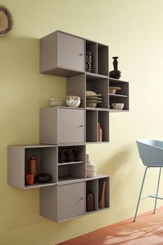 a room with a chair and some shelves on the wall next to a table in front of it