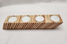 three tealight candles in a wooden holder