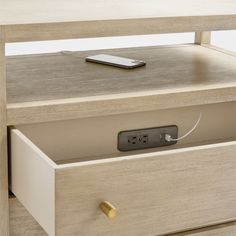 a wooden table with two drawers and a remote control on the top one drawer is open