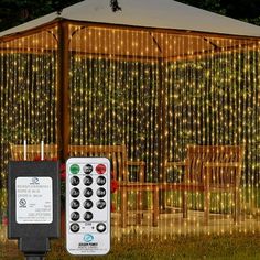 a remote control sitting in front of a gazebo decorated with lights and string lights