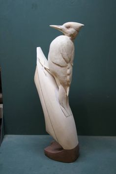 a sculpture of a bird sitting on top of a surfboard