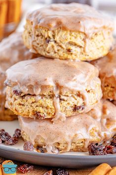 there are three doughnuts with icing on top of each one and some cinnamon rolls in the background