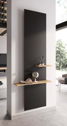 two shelves with books on them in a living room next to a wall mounted clock