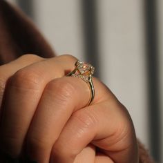 a person holding a diamond ring in their hand