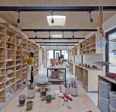 two people working in a large room with lots of wooden shelves and shelving on the walls