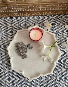 a candle and some flowers on a tray