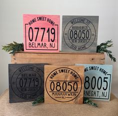 four wooden signs with names on them sitting on top of a table in front of a potted plant