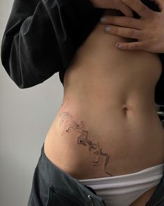 a woman's stomach with a tattoo on it