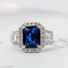 a ring with a blue stone surrounded by diamonds