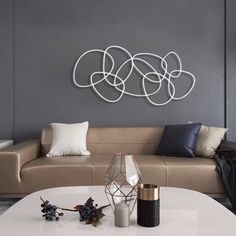 a living room filled with furniture and pillows on top of a white table in front of a gray wall