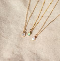 Our Dainty gemstone necklace features a tiny little stone, choose between opal, moonstone and turquoise.  DETAILS *PENDANT is Genuine Turquoise, Genuine Moonstone, or Synthetic Opal, measuring 5 x 7mm *CHAIN is 14k Gold Filled or Sterling Silver *CLASP is 14k Gold Filled or Sterling Silver Matching  PERSONALIZE IT!  ADD A STAR INITIAL CHARM: https://www.etsy.com/ca/listing/627638174/add-a-star-initial-charm ADD A STAMPED INITIAL: https://www.etsy.com/ca/listing/561708083/add-an-initial ADD A BIR Dainty Opal Round Pendant Necklace, Everyday Opal Jewelry With Gemstones, Everyday Opal Gemstone Jewelry, Dainty Opal Pendant Necklace, Delicate Opal Gemstone Jewelry, Delicate Moonstone Necklace With Delicate Chain, Dainty Adjustable Moonstone Necklace, Delicate Opal Jewelry With Birthstone, Delicate Opal Birthstone Jewelry