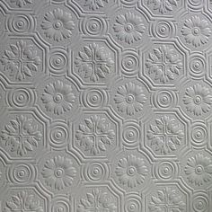 a white wall with an intricate pattern on it