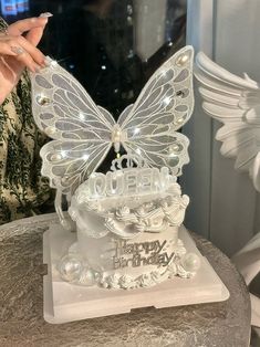 a close up of a cake with a butterfly on it and lights in the shape of a birthday cake