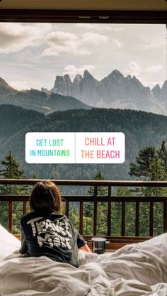 a person sitting on a bed with mountains in the background and a sign that says get lost, chill at the beach