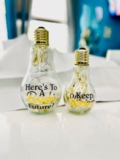 two glass bottles with words on them sitting on a table