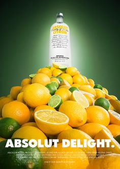 an advertisement for absolut delight with lemons and limes stacked on top of each other