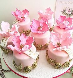 a cake with pink flowers on it sitting on a table next to a card and chain