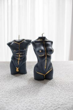 two black candles with gold zippers on them