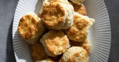 some biscuits on a white paper plate with a gray table in the backgroud