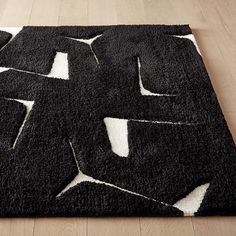 a black and white rug on top of a wooden floor