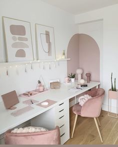 a white desk topped with pink chairs next to a wall mounted art work area and potted plants