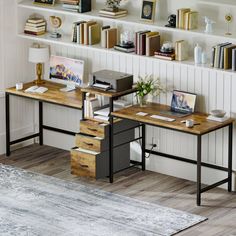 a room with two desks and bookshelves on the wall above them, along with a rug