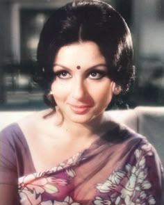 an old photo of a woman with dark hair and blue eyes wearing a sari