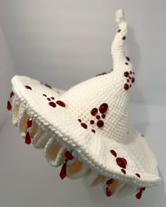 a white knitted hat with red dots on it