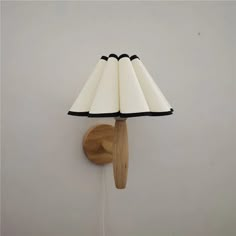 a lamp that is on the wall with a wooden stick attached to it's side