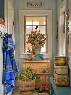 an entryway with baskets and flowers in it